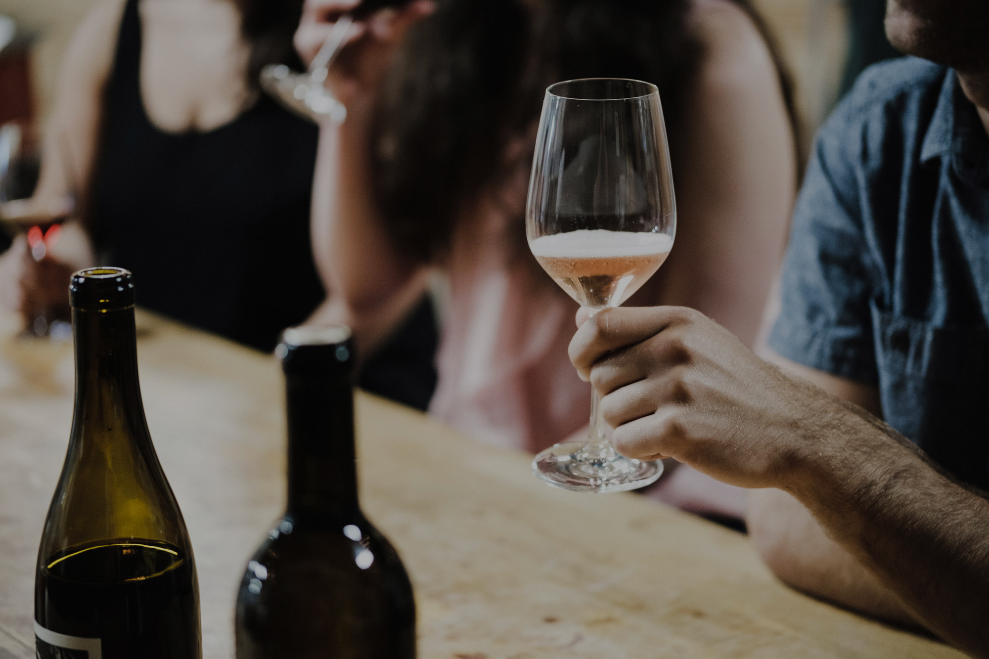 Man holding a wine glass with rose for a wine tasting.